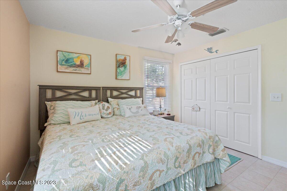 7667 North Wickham Road, Unit 916 Melbourne, FL 32940 - Photo 31 of 53 a bedroom with a large bed and a chandelier
