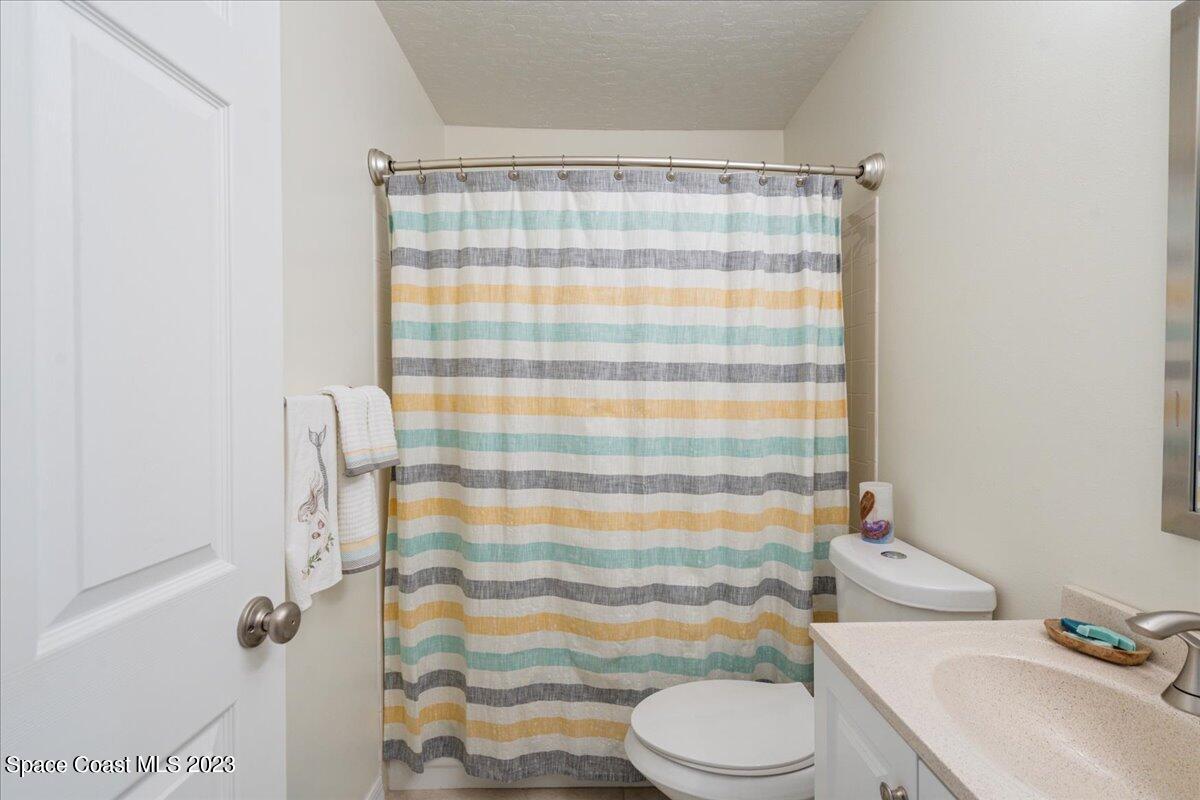 7667 North Wickham Road, Unit 916 Melbourne, FL 32940 - Photo 35 of 53 a bathroom with a sink toilet and shower curtain