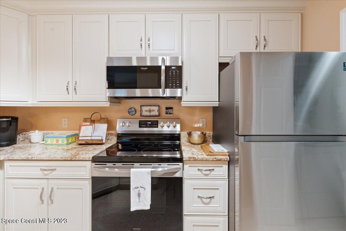 7667 North Wickham Road, Unit 916 Melbourne, FL 32940 - Photo 41 of 53 a kitchen with stainless steel appliances a refrigerator stove and microwave