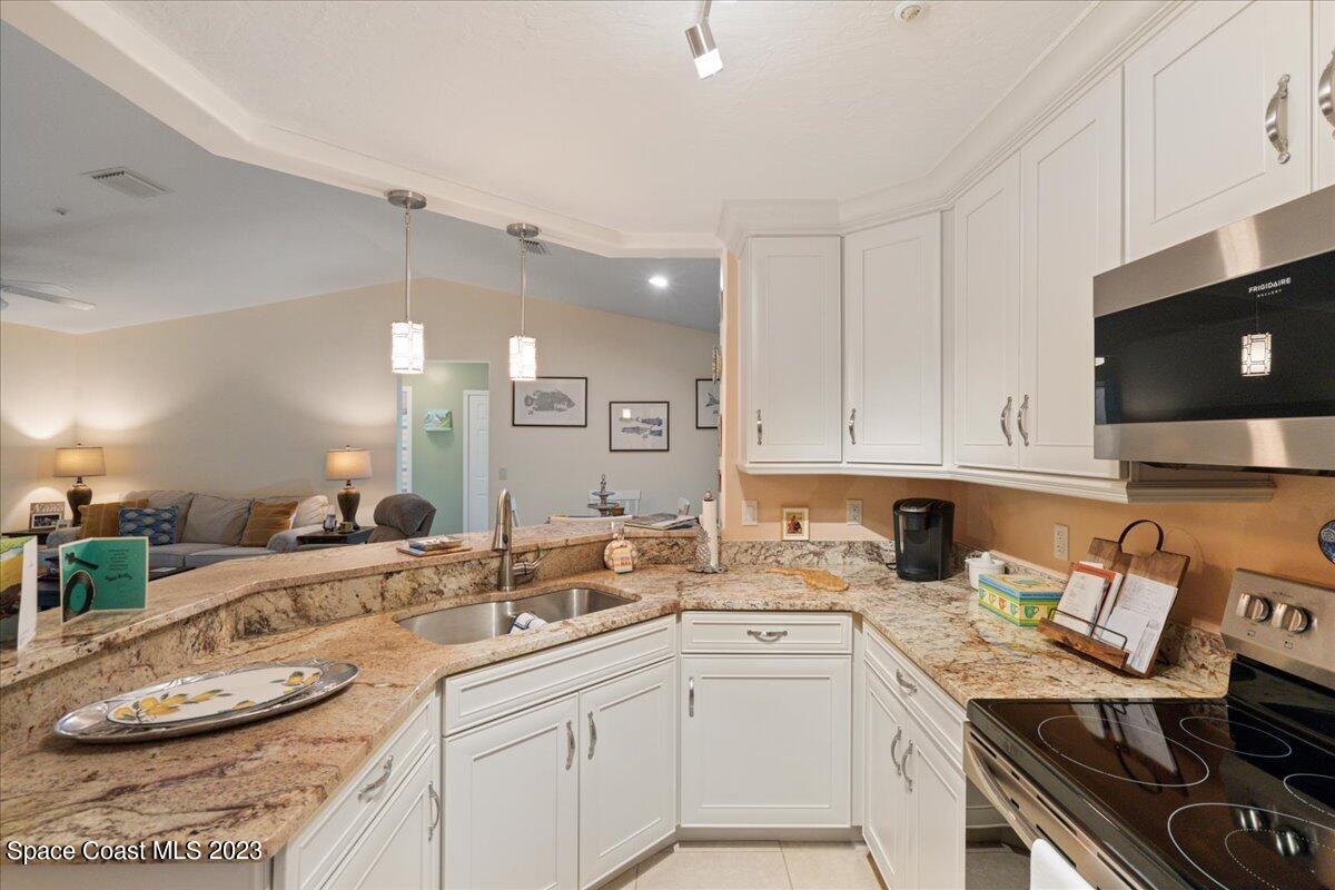 7667 North Wickham Road, Unit 916 Melbourne, FL 32940 - Photo 7 of 53 a kitchen with a sink stove and cabinets