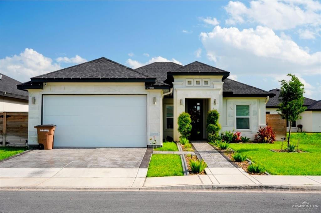 2700 East Comal Road Edinburg, TX 78542 - Photo 2 of 3 a front view of yellow house with a yard and plants