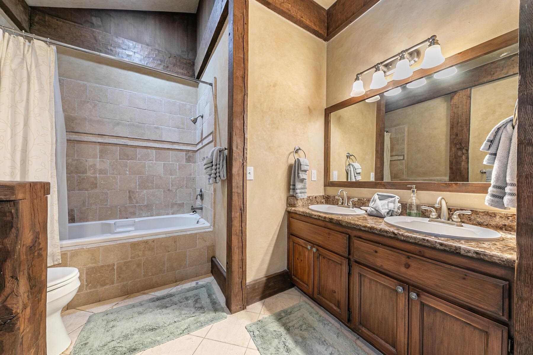 12209 Greenleaf Way Truckee, CA 96161 - Photo 17 of 28 a bathroom with a tub a sink and mirror