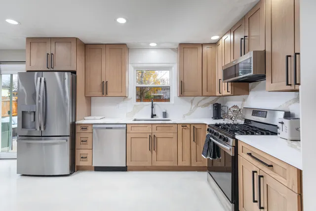 a kitchen with stainless steel appliances a refrigerator sink and stove