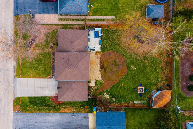 a front view of a house with a garden and trees