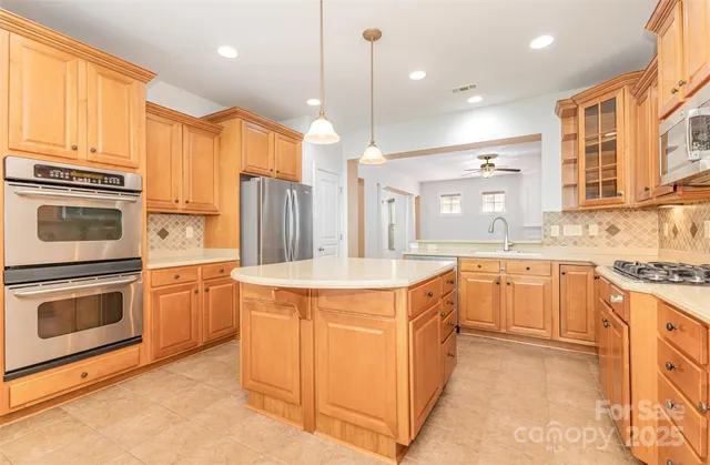 a kitchen with stainless steel appliances granite countertop a stove a sink and a refrigerator