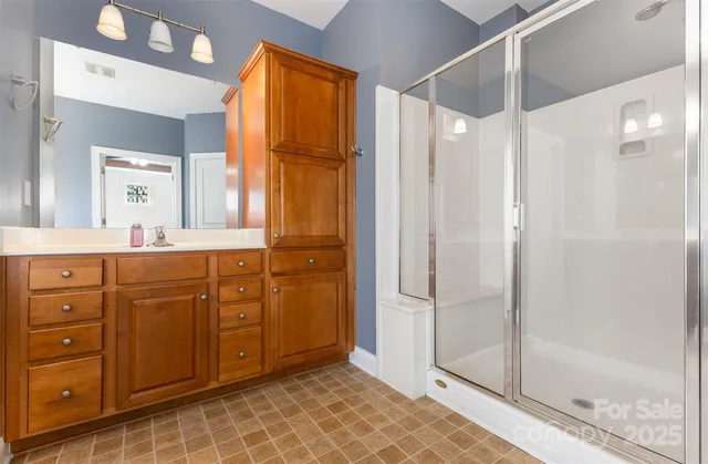 a bathroom with a granite countertop sink mirror and shower