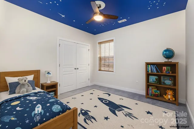 en empty room with windows and chandelier fan