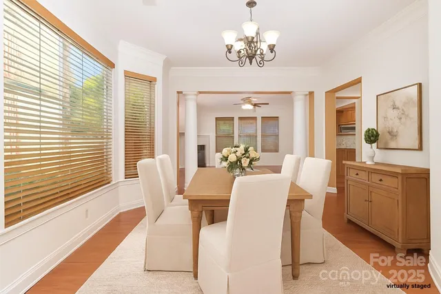 a view of a dining room with furniture a chandelier and wooden floor