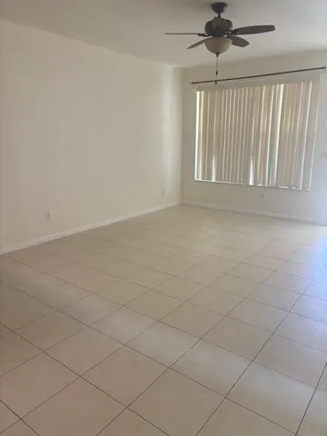 a view of a room with wooden floor and a ceiling fan