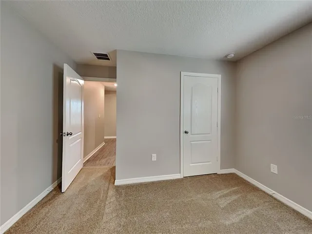 a view of an empty room and closet area