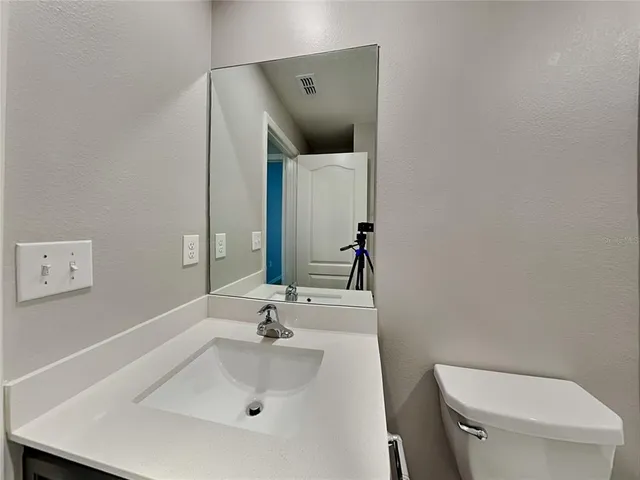 a bathroom with a sink and mirror with toilet