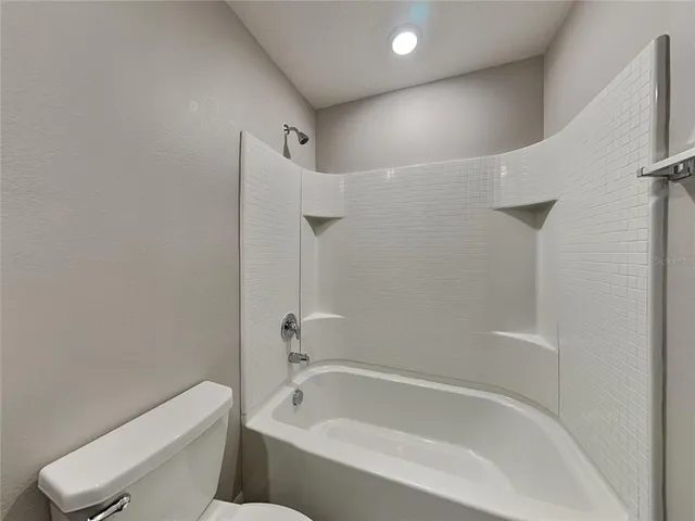 a white bath tub sitting next to a toilet