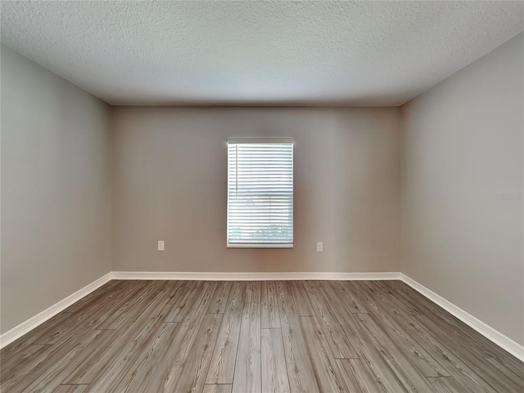 Undisclosed Address Lakeland, FL 33811 - Photo 5 of 17 a view of an empty room with wooden floor and a window