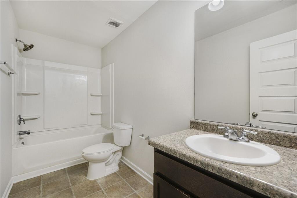 323 Bandelier Circle Hampton, GA 30228 - Photo 25 of 28 a bathroom with a granite countertop sink toilet and shower