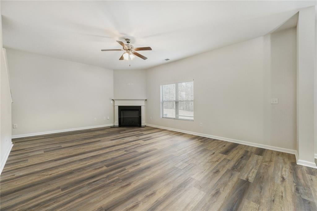 323 Bandelier Circle Hampton, GA 30228 - Photo 6 of 28 an empty room with wooden floor ceiling fan and windows