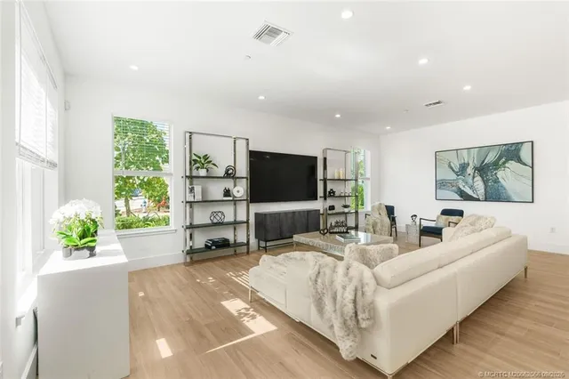 a living room with furniture kitchen view and a large window