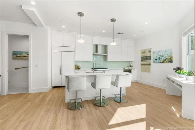 a kitchen with stainless steel appliances a sink a stove and a wooden floors
