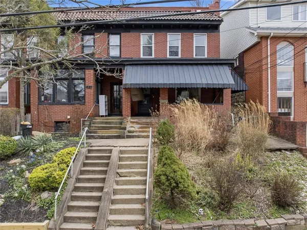 a front view of a house with a garden