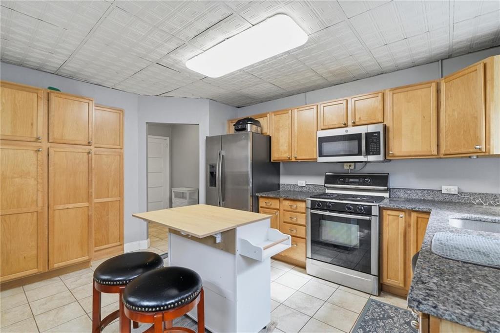 633 Gettysburg Street Pittsburgh, PA 15206 - Photo 11 of 32 a kitchen with stainless steel appliances granite countertop a sink a stove a microwave a counter top space and cabinets