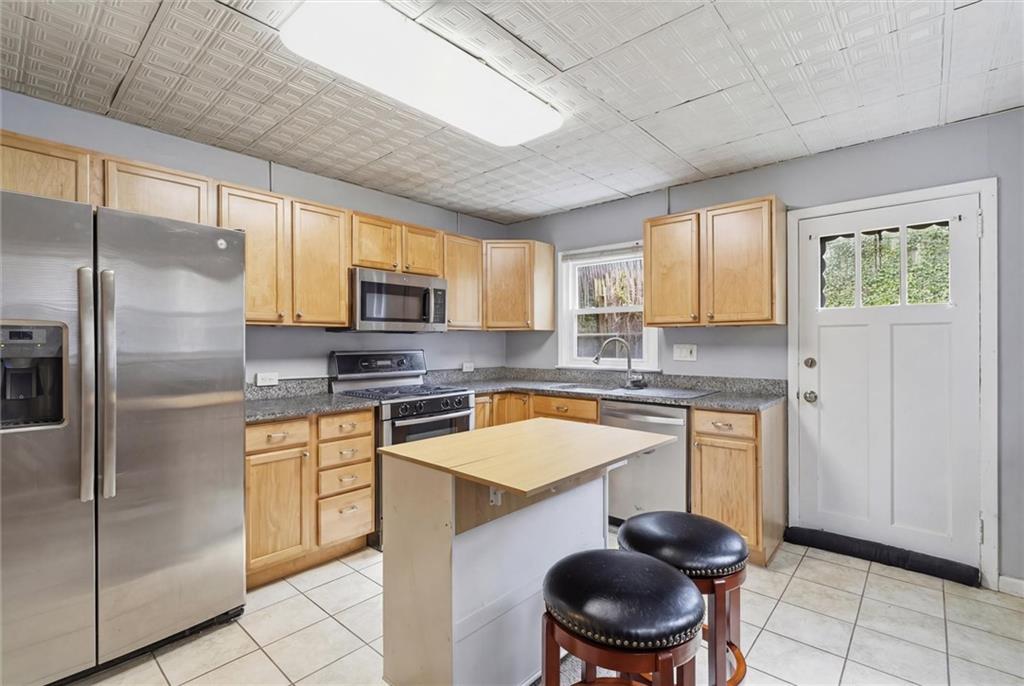 633 Gettysburg Street Pittsburgh, PA 15206 - Photo 12 of 32 a kitchen with stainless steel appliances granite countertop a stove a sink dishwasher a refrigerator and a microwave