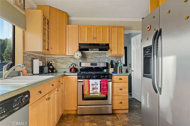 a kitchen with stainless steel appliances granite countertop a stove a refrigerator and a sink