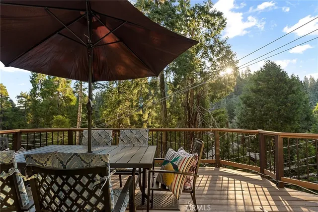 a view of a roof deck with table and chairs under an umbrella