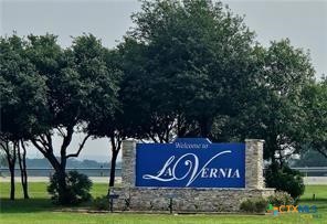 a sign board with a tree in the background