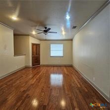 113 Micah Point, Unit B La Vernia, TX 78121 - Photo 2 of 7 an empty room with wooden floor and windows