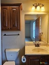 113 Micah Point, Unit B La Vernia, TX 78121 - Photo 5 of 7 a bathroom with a toilet sink and mirror
