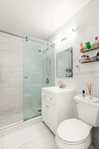 a living room with furniture potted plant floor to ceiling windows and a flat screen tv