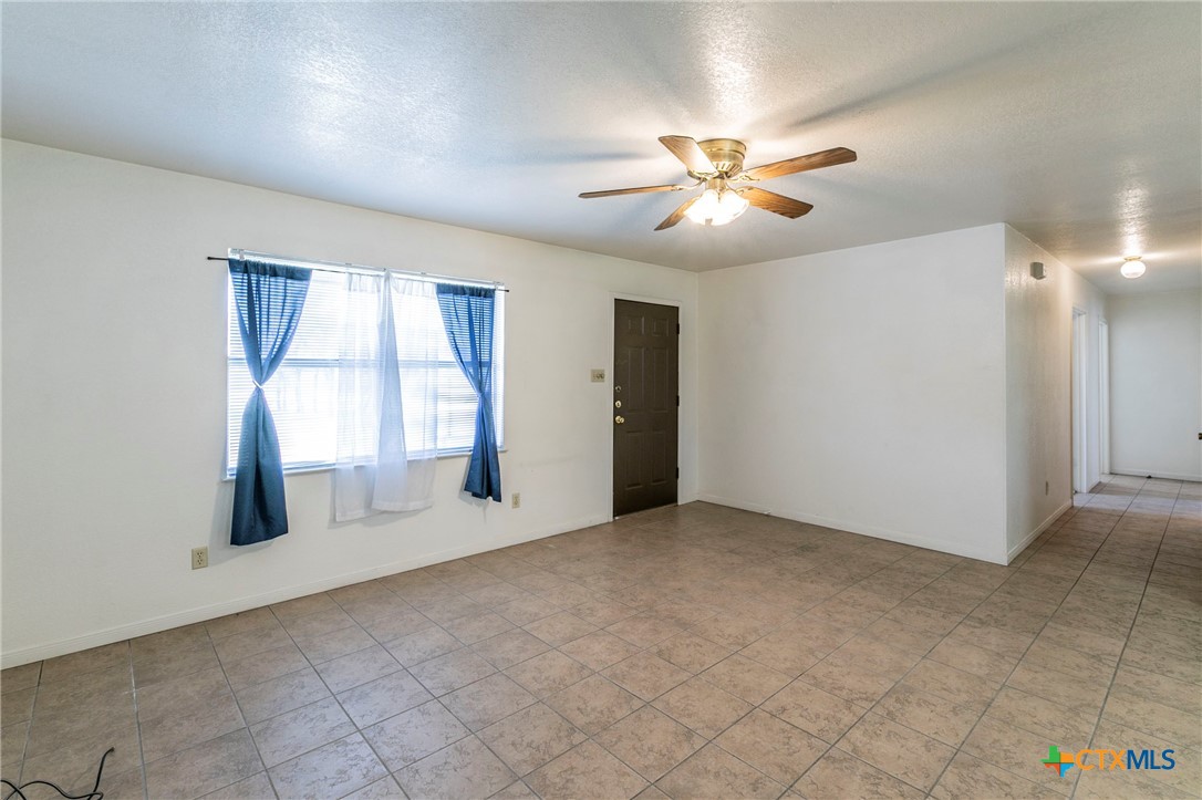 1001 Cherokee Trail Kempner, TX 76522 - Photo 4 of 18 an empty room with chandelier fan and windows