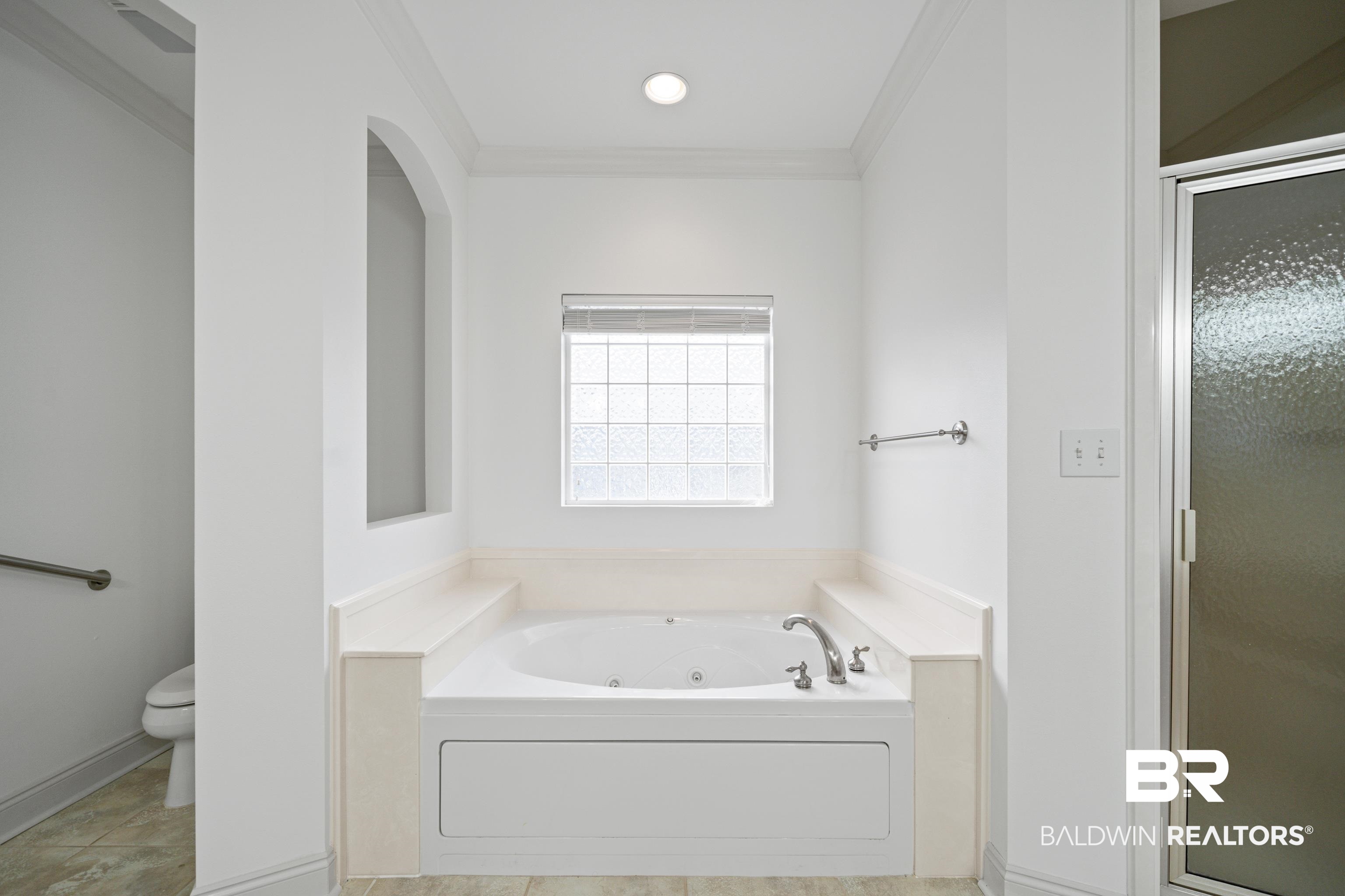 404 Savannah Lane Foley, AL 36535 - Photo 24 of 29 Bathroom with tile patterned flooring, toilet, ornamental molding, a shower stall, and a whirlpool tub