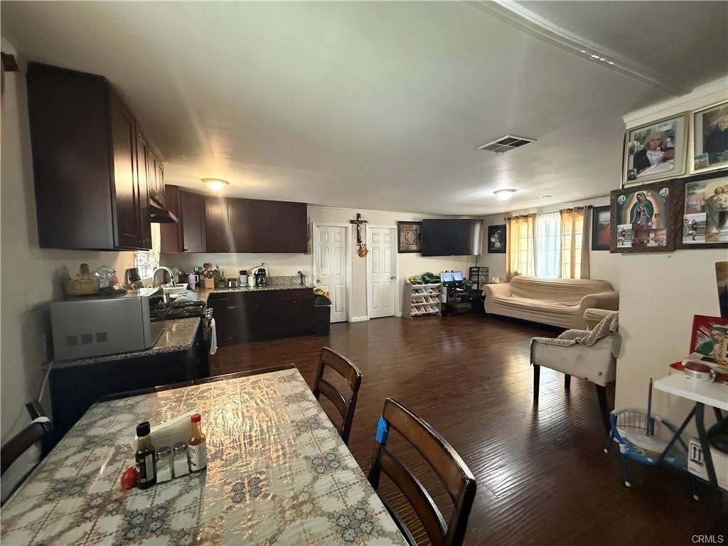 12700 Elliot, Unit 456 El Monte, CA 91732 - Photo 28 of 37 a kitchen with stainless steel appliances granite countertop a refrigerator oven stove a dining table and chairs with wooden floor