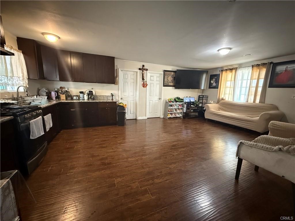 12700 Elliot, Unit 456 El Monte, CA 91732 - Photo 33 of 37 a kitchen with stainless steel appliances granite countertop a refrigerator a sink dishwasher a dining table and chairs with wooden floor