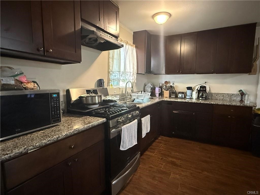 12700 Elliot, Unit 456 El Monte, CA 91732 - Photo 35 of 37 a kitchen with stainless steel appliances granite countertop a sink a stove and a wooden cabinets
