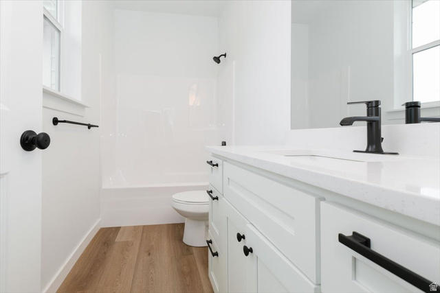 314 North 200 West Logan, UT 84321 - Photo 16 of 37 Full bath with healthy amount of natural light, vanity, light wood-style floors, and shower / bathtub combination