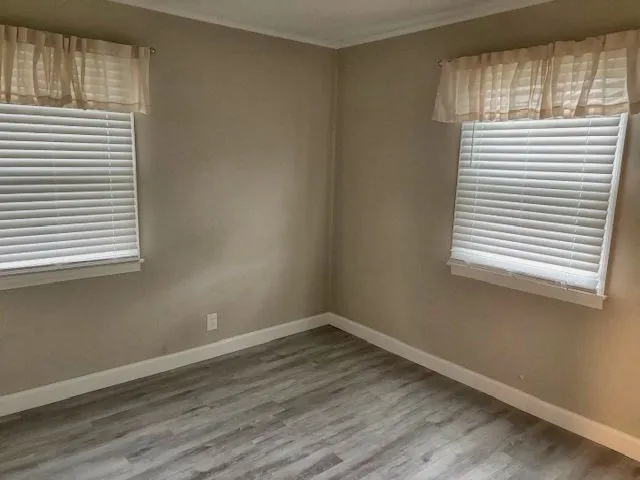 an empty room with wooden floor and sliding door