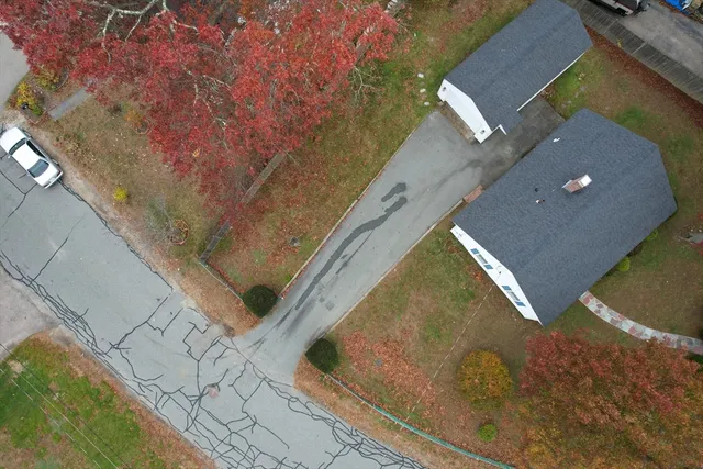 a view of a house with a yard and large tree