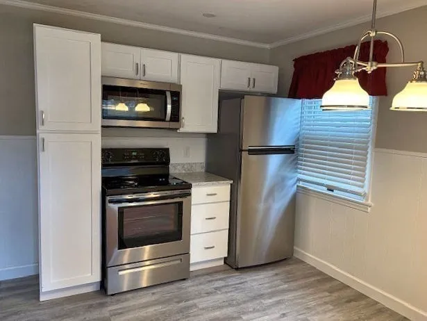 a kitchen with granite countertop white cabinets and stainless steel appliances