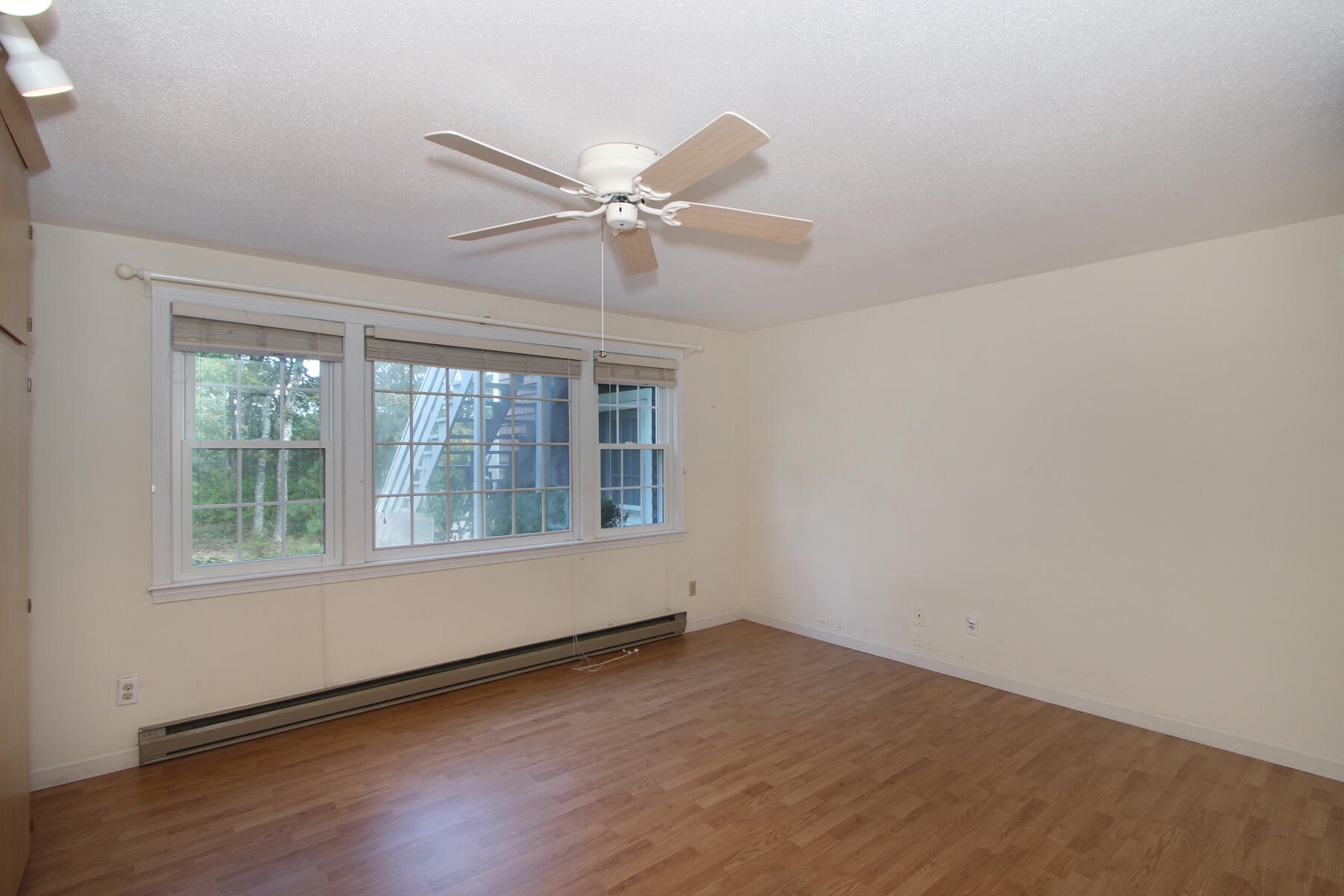 222 Buck Island Road, Unit 53 West Yarmouth, MA 02673 - Photo 12 of 23 an empty room with wooden floor fan and windows