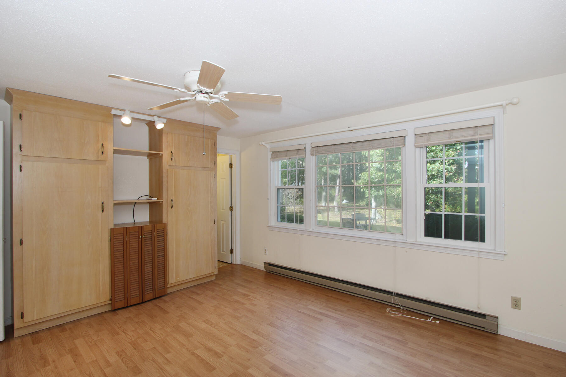 222 Buck Island Road, Unit 53 West Yarmouth, MA 02673 - Photo 13 of 23 an empty room with wooden floor cabinet and windows