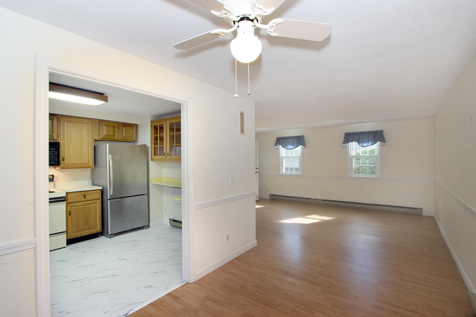 222 Buck Island Road, Unit 53 West Yarmouth, MA 02673 - Photo 7 of 23 an empty room with chandelier and stainless steel appliances