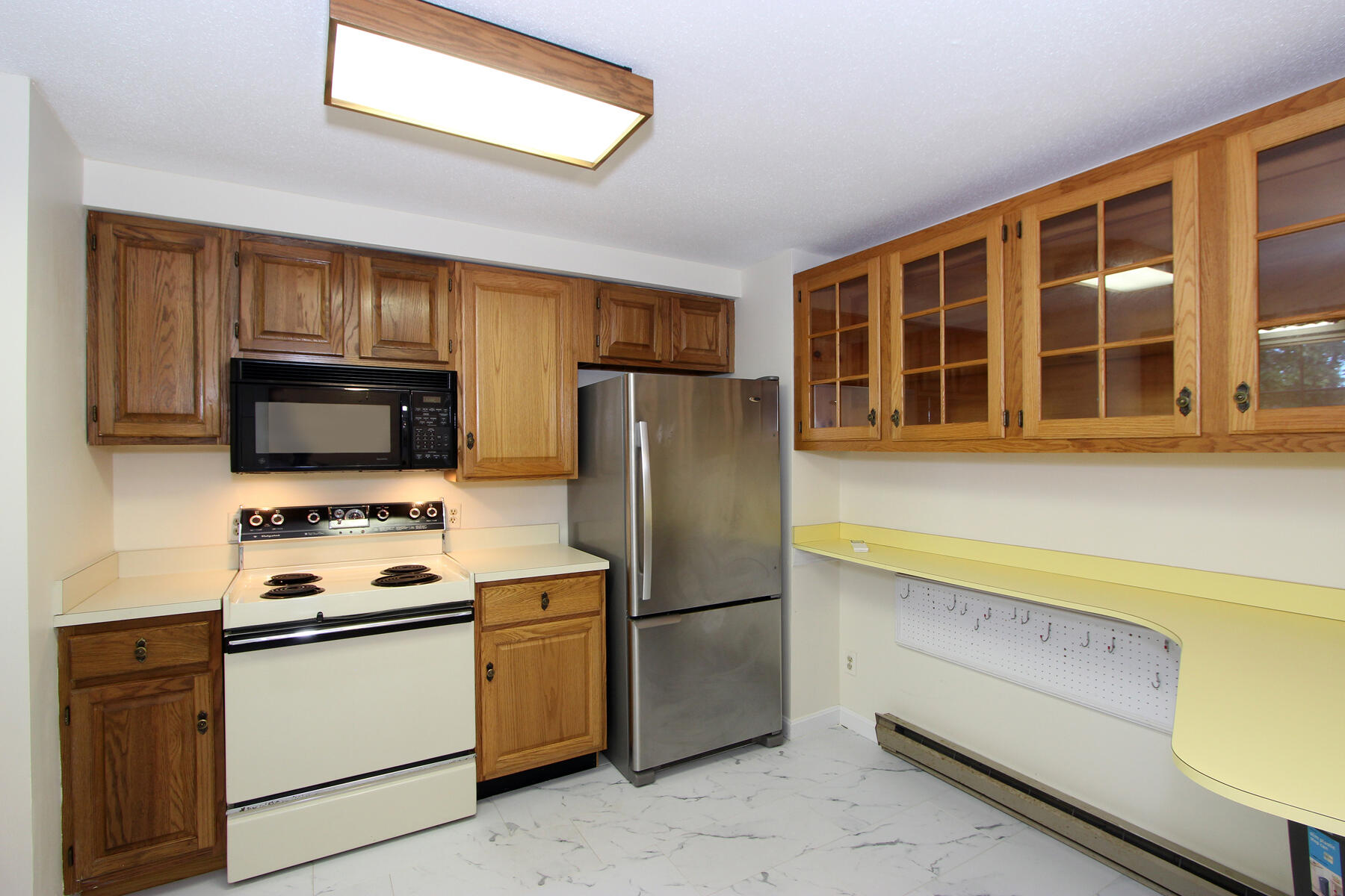 222 Buck Island Road, Unit 53 West Yarmouth, MA 02673 - Photo 9 of 23 a kitchen with a refrigerator stove and microwave