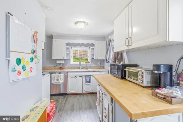 a kitchen with stainless steel appliances granite countertop a sink and dishwasher a stove a refrigerator with wooden floor