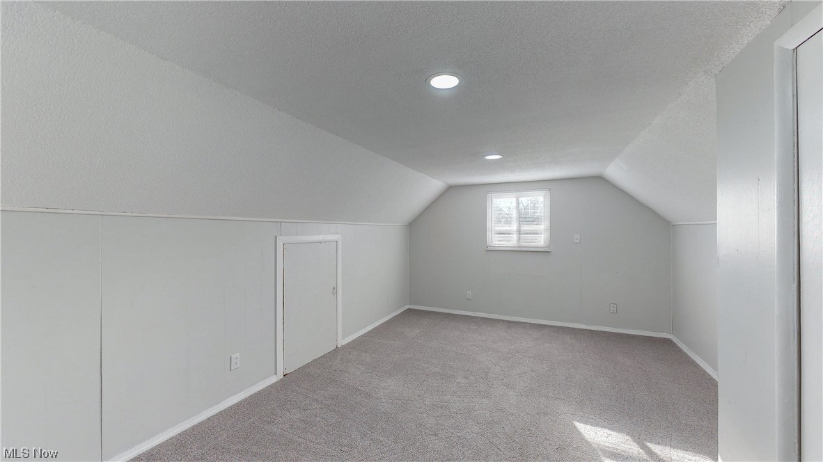 1466 Scenic Way Akron, OH 44310 - Photo 18 of 35 Bonus room featuring light carpet, vaulted ceiling, and a textured ceiling