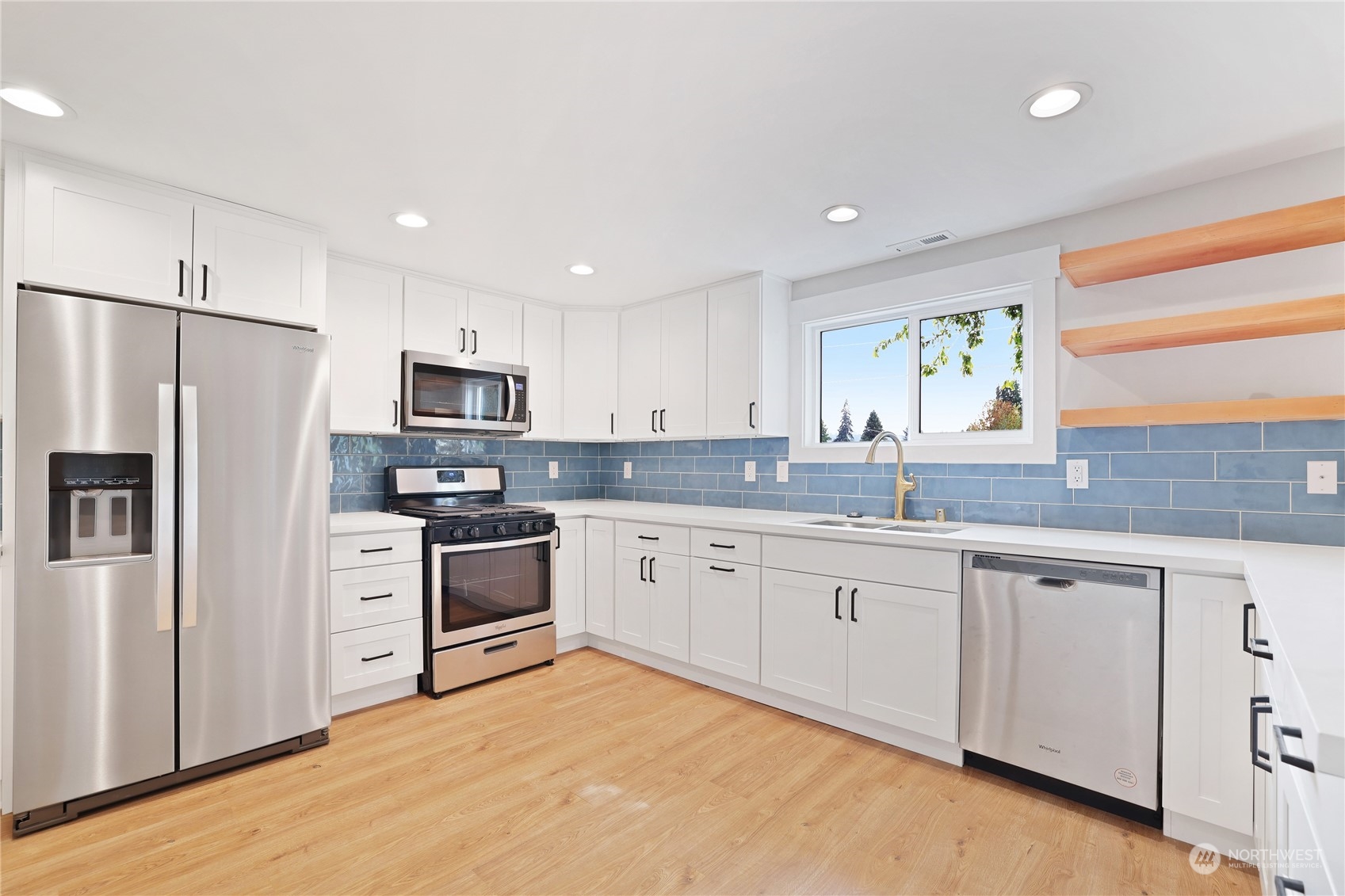 5954 49th Avenue Southwest, Unit A Seattle, WA 98136 - Photo 5 of 12 a kitchen with white cabinets stainless steel appliances and a window