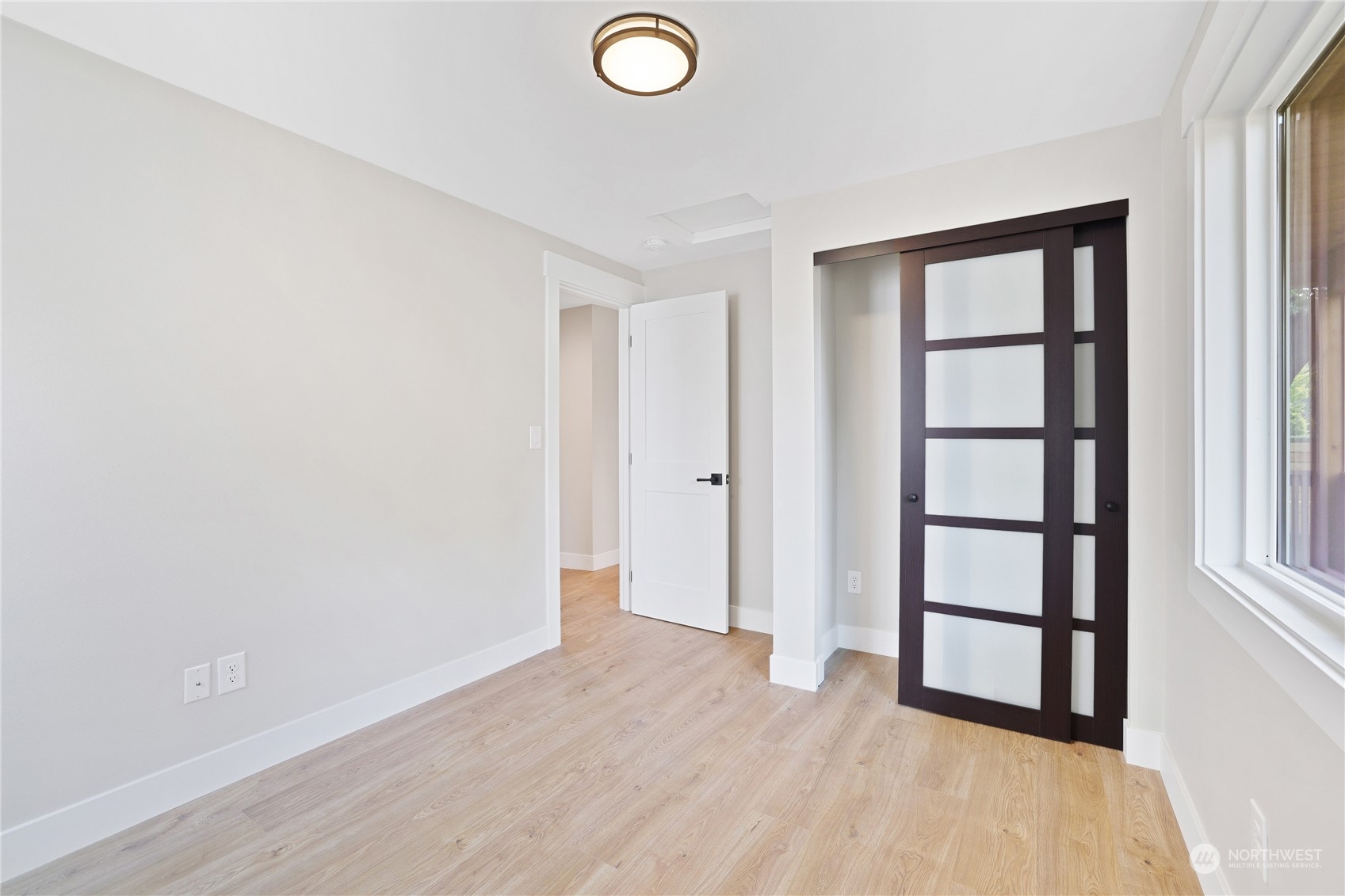 5954 49th Avenue Southwest, Unit A Seattle, WA 98136 - Photo 6 of 12 an empty room with wooden floor and windows
