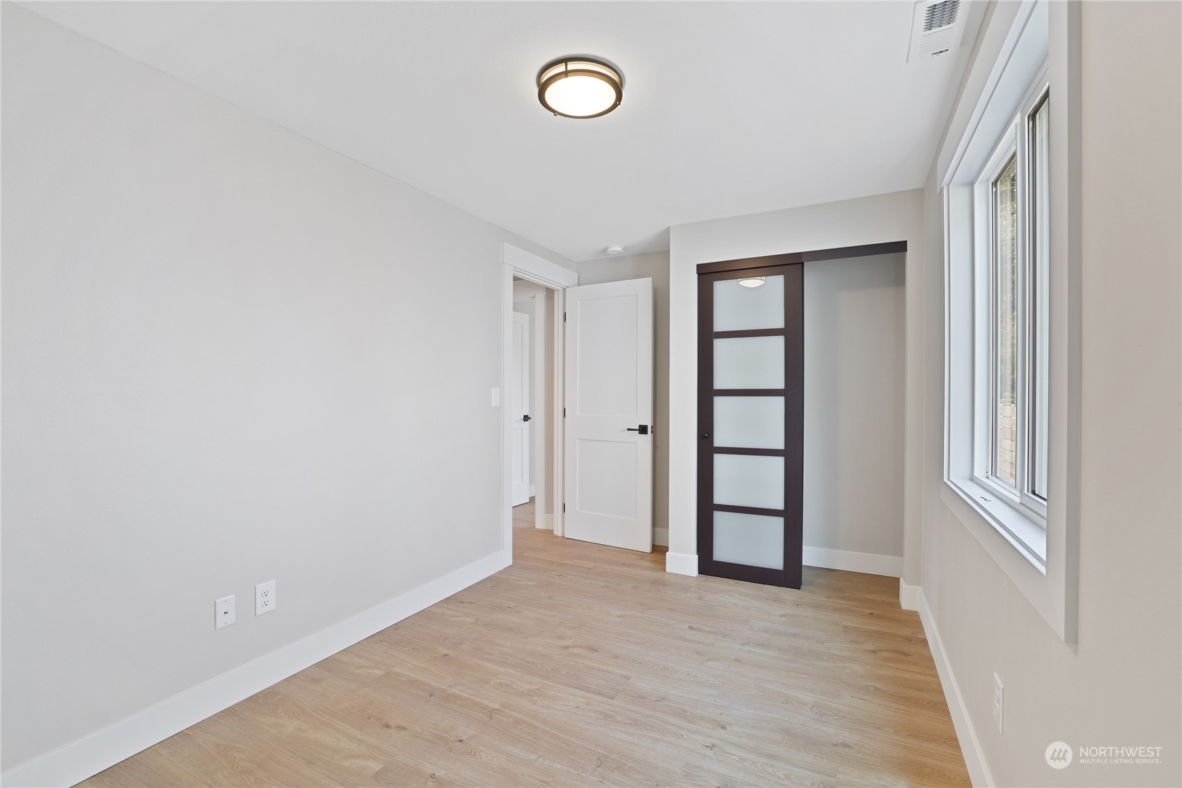 5954 49th Avenue Southwest, Unit A Seattle, WA 98136 - Photo 8 of 12 a view of an empty room with a window and wooden floor