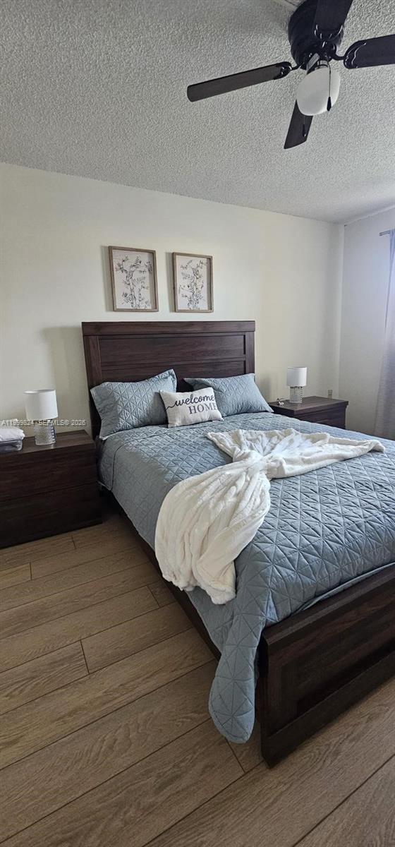 2801 North Pine Island Road, Unit 207 Sunrise, FL 33322 - Photo 6 of 11 a bedroom with a bed and wooden floor