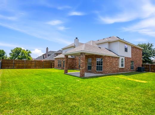 5034 West Fall Drive Midlothian, TX 76065 - Photo 38 of 40 Expansive fenced backyard featuring a covered patio, brick exterior, and multiple windows
